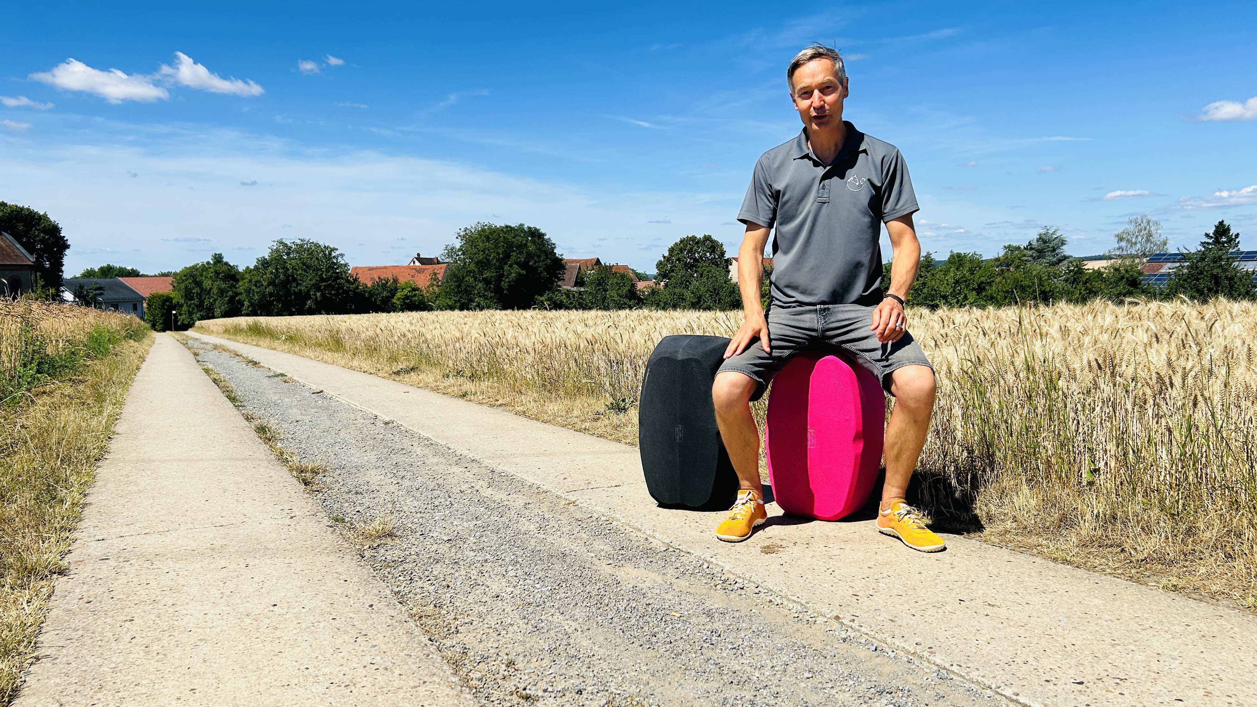 Mann auf zwei hockblocs auf einem Feldweg